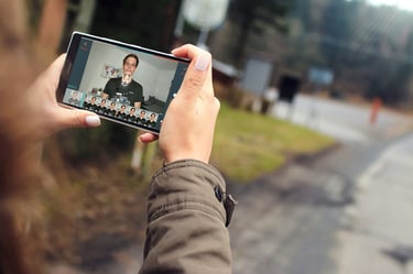 Eine Frau schaut sich am Smartphone den Kurs zu Filmora Go mit Konstantin Ristl an