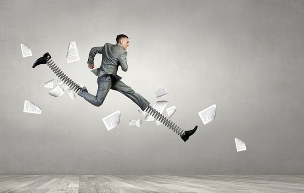 Businessman in suit jumping with big springs on feet.jpeg