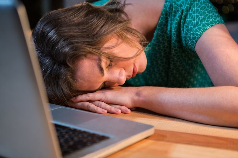 Frau schläft am Laptop: Geld im Schlaf verdienen funktioniert auch mit Online-Kursen nicht 